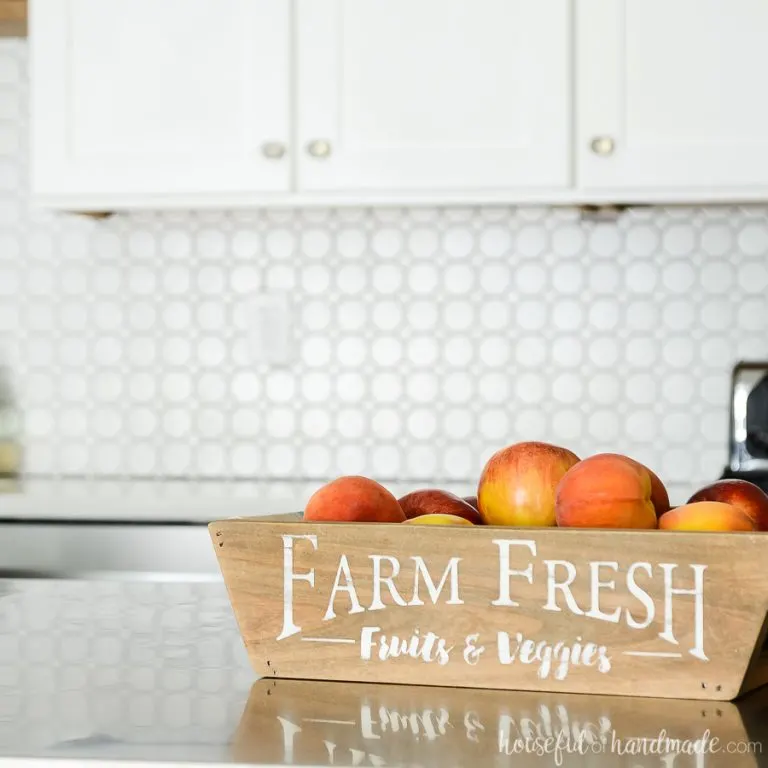 Wood farm fresh produce basket with fabric sling full of fruits.