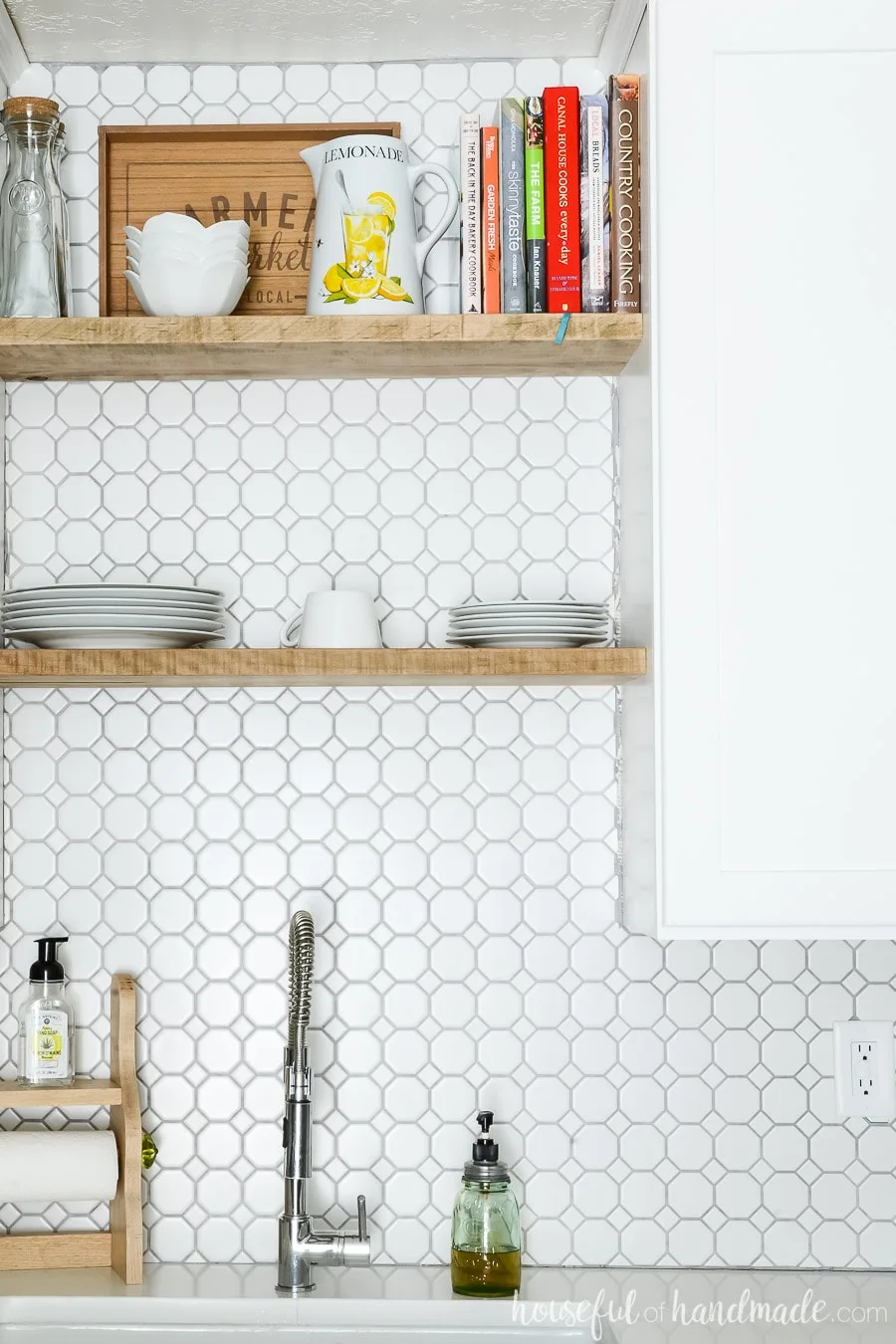 Close-up of chunky open shelving about kitchen sink. Retro octagon white backsplash tile with gray grout. 