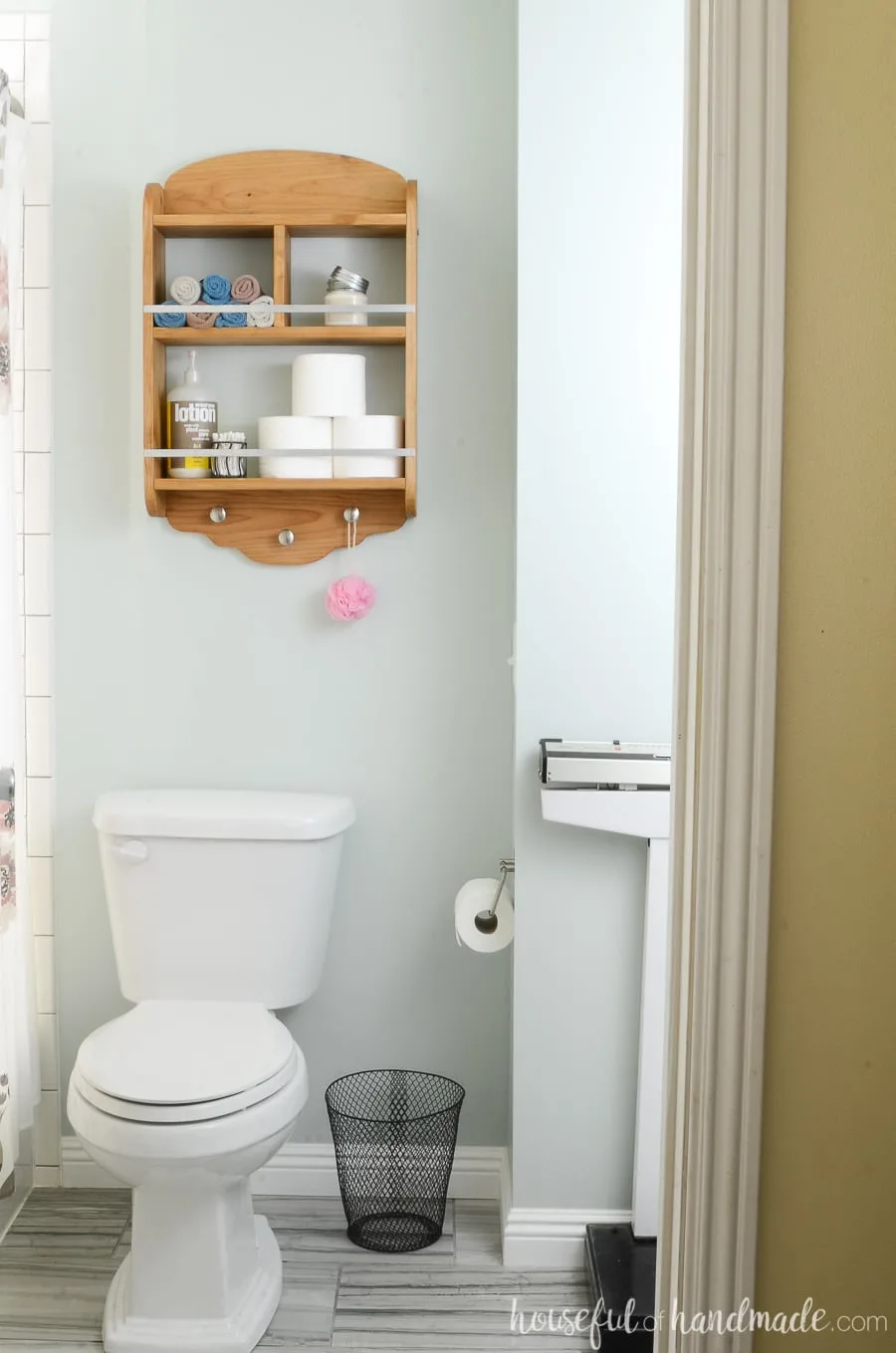 Looking into the bathroom at the new bathroom storage shelves above the toilet. Knotty alder wood shelves store all the bathroom necessities. 