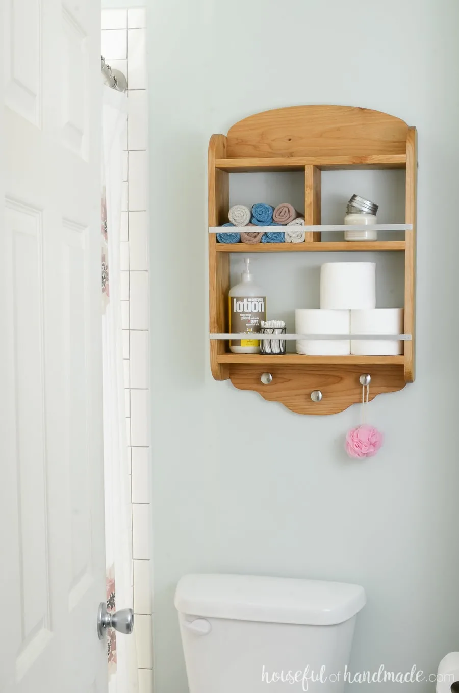 DIY bathroom storage shelves to hang above the toilet for extra storage. Wood shelves holding toilet paper, lotion and wash cloths. 