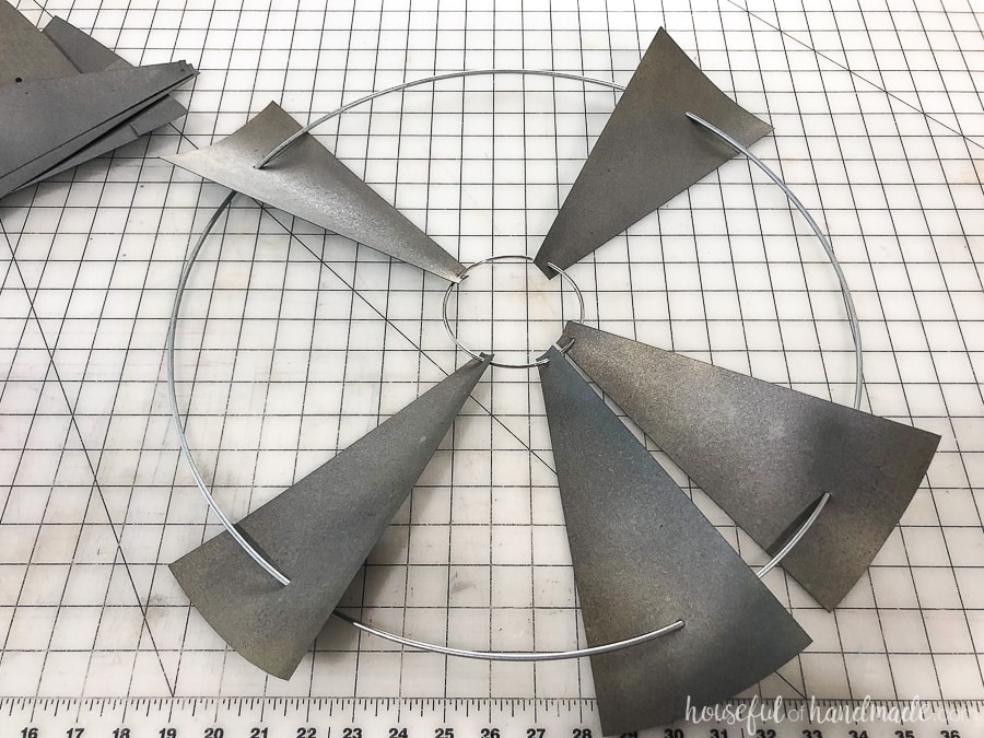 Threading the paper decorative windmill blades on the metal rings.