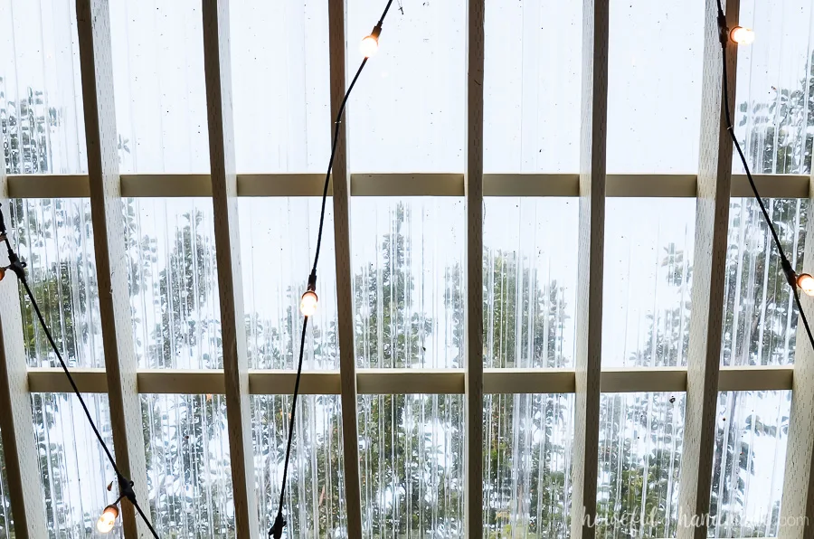 View looking through the clear pergola roof to the sky. Outdoor hanging lights make this outdoor space a 3 season patio. 