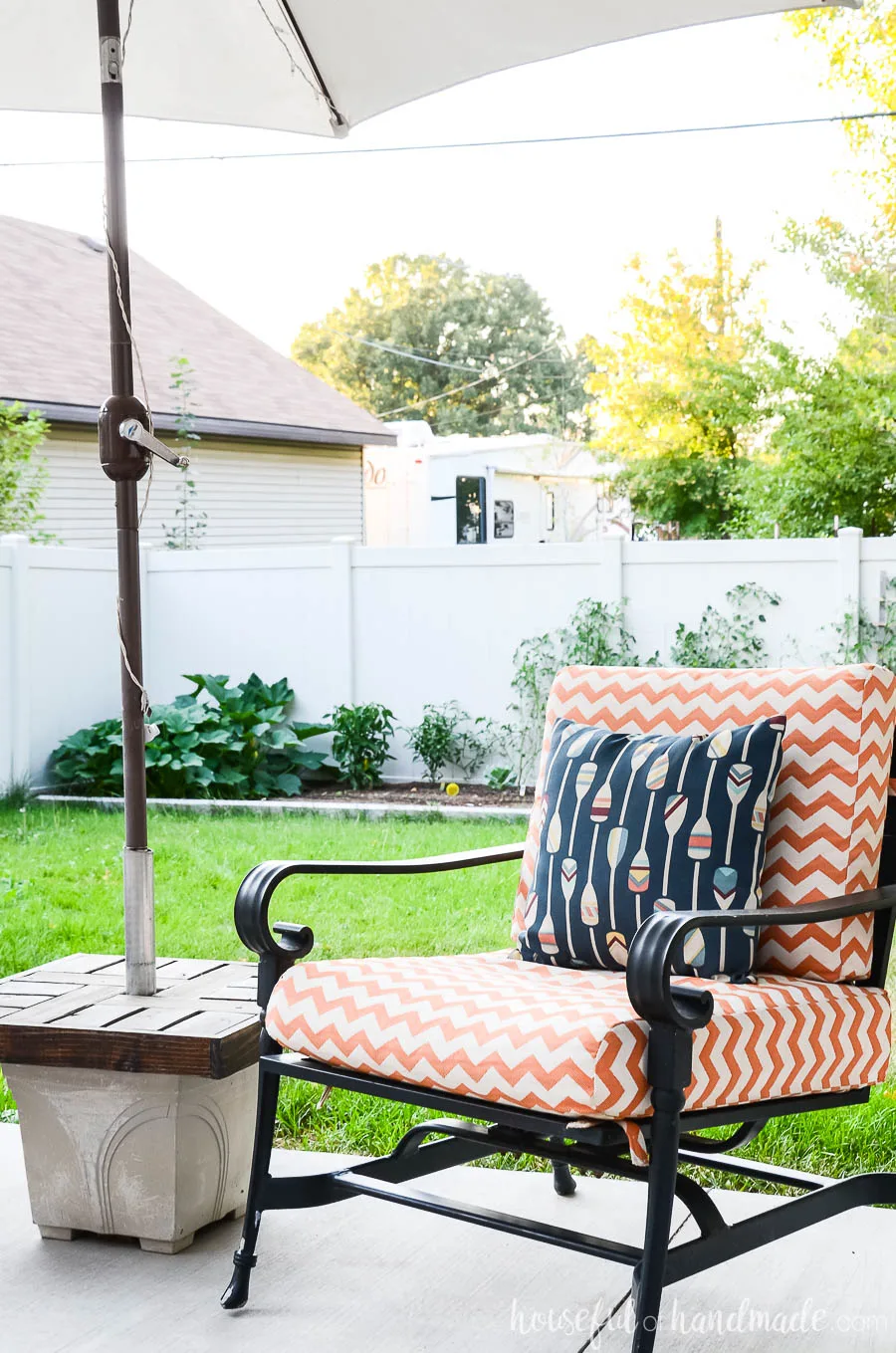 Handmade umbrella stand side table next to orange and white striped outdoor chair is one of our favorite outdoor living spaces. 