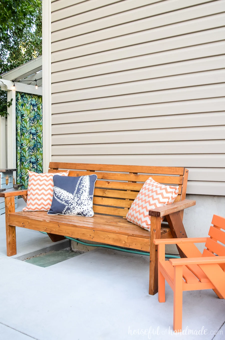 Slatted outdoor bench and kids chair with bright colored pillows make the perfect sitting area for one of our outdoor living spaces. 