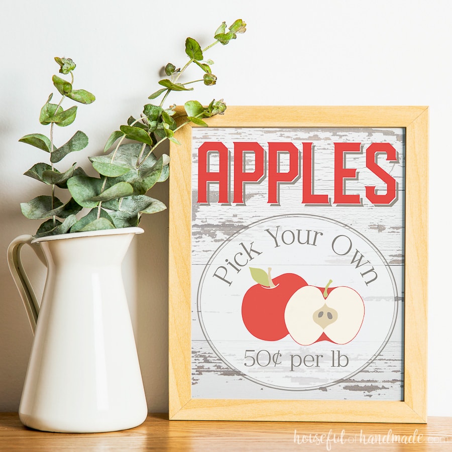 Beautiful free printable apple picking sign next to a farmhouse pitcher of greenery. 