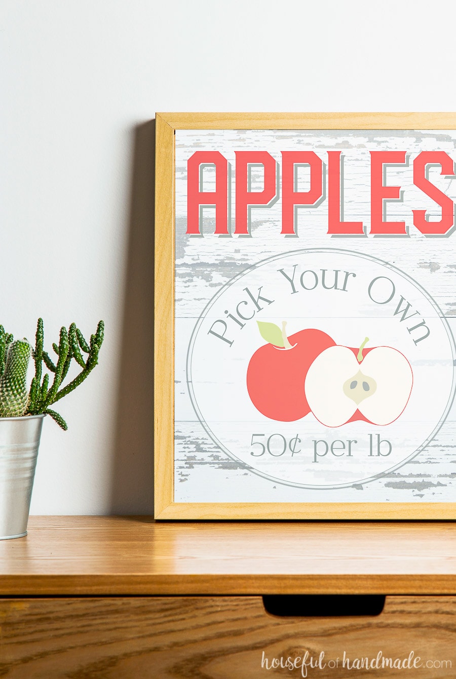 Apples Pick Your Own printable sign for fall decor in a frame on a table.