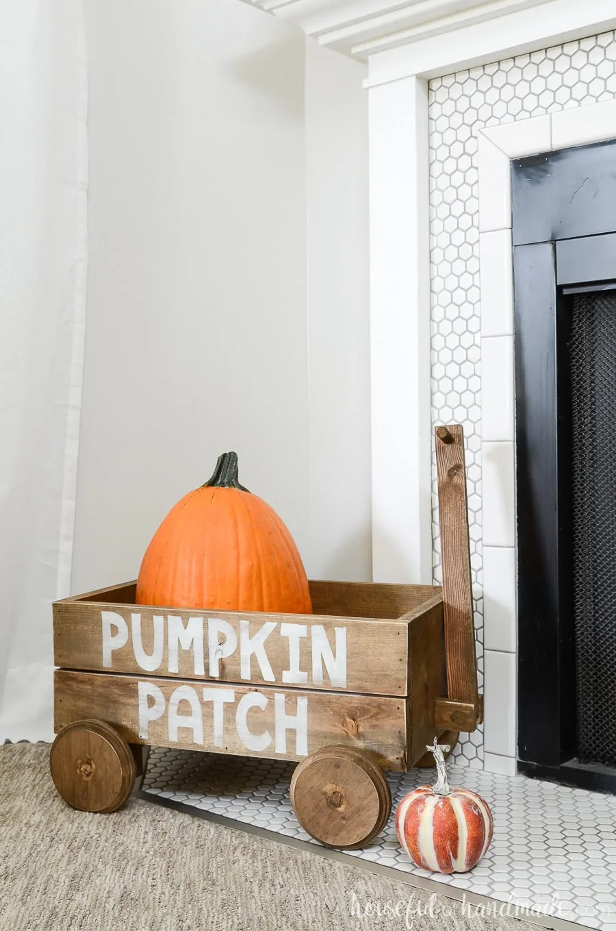 Aged wood wagon decor with pumpkin patch design on the side for fall fireplace decor. 