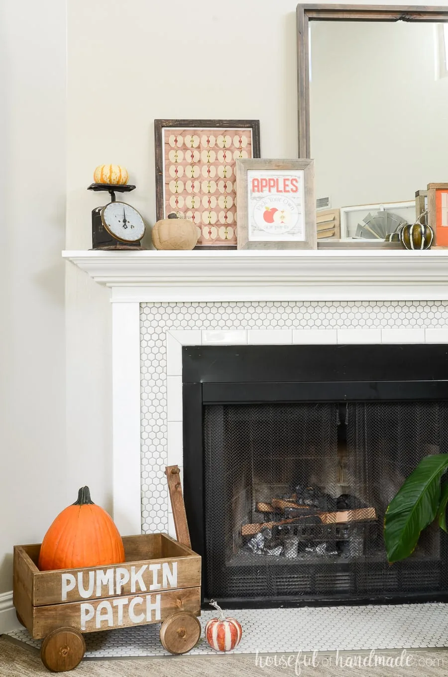 View of the entire fall mantel with the decorative wood wagon holding the pumpkin on the hearth.