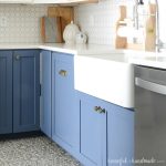 White farmhouse sink installed in a DIY farmhouse sink base cabinet painted blue.