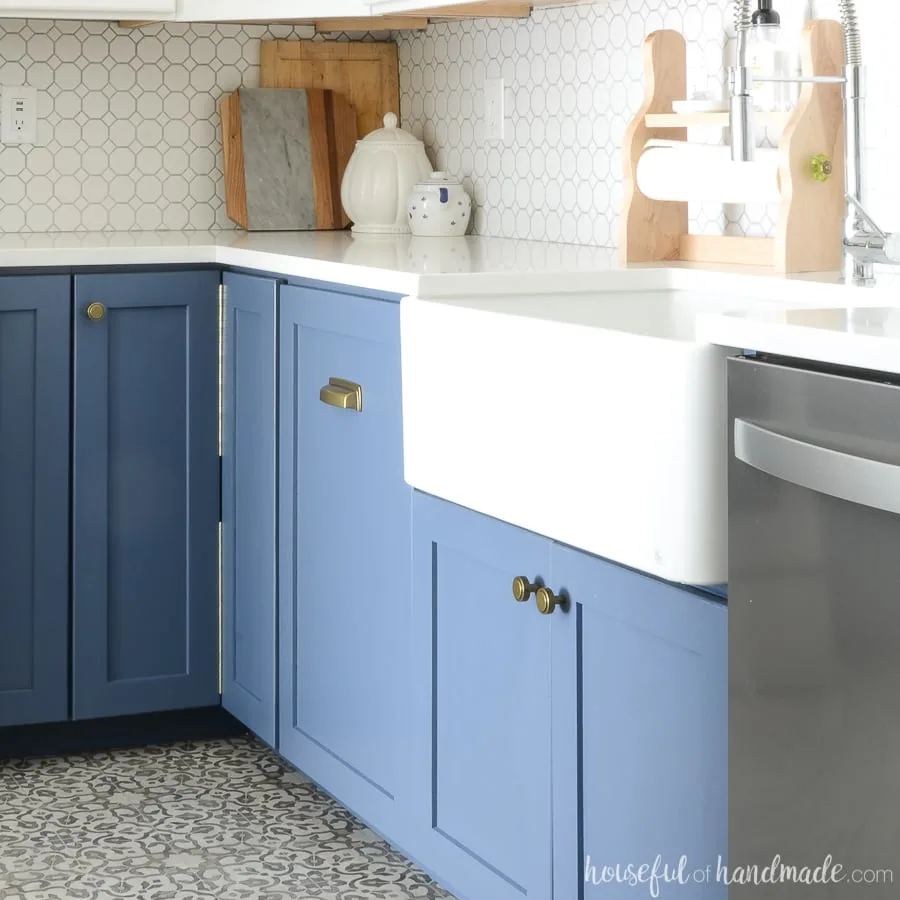 White farmhouse sink installed in a DIY farmhouse sink base cabinet painted blue. 