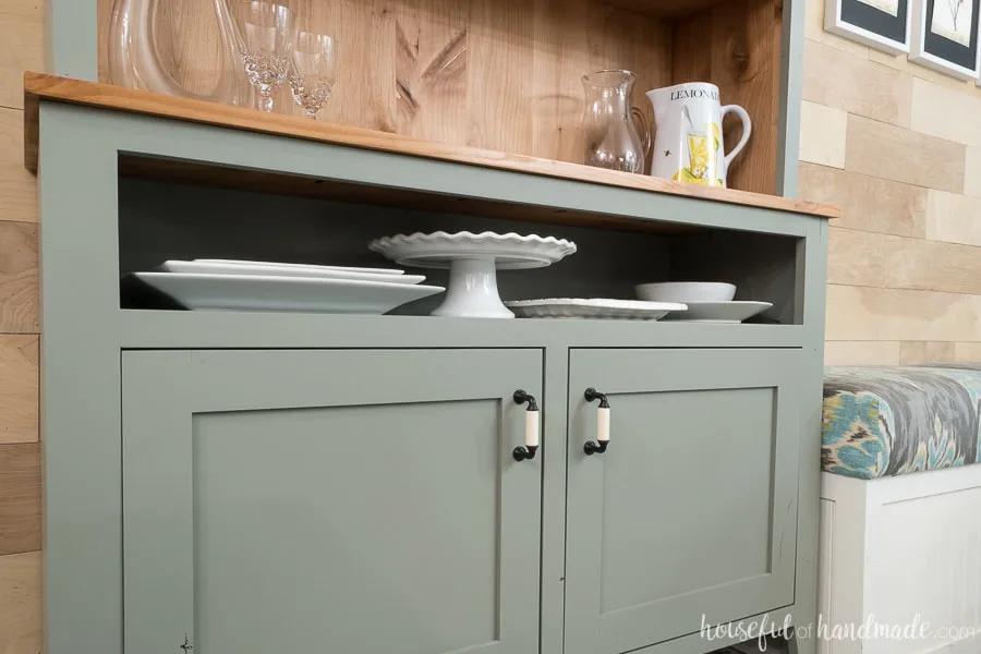 A narrow open shelf at the top of the dining room hutch is perfect for displaying and storing platters.