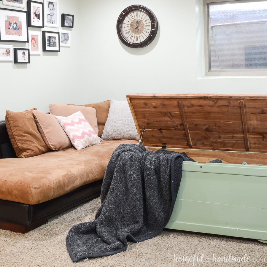 Green upcycled storage chest full of blankets being used as a coffee table.