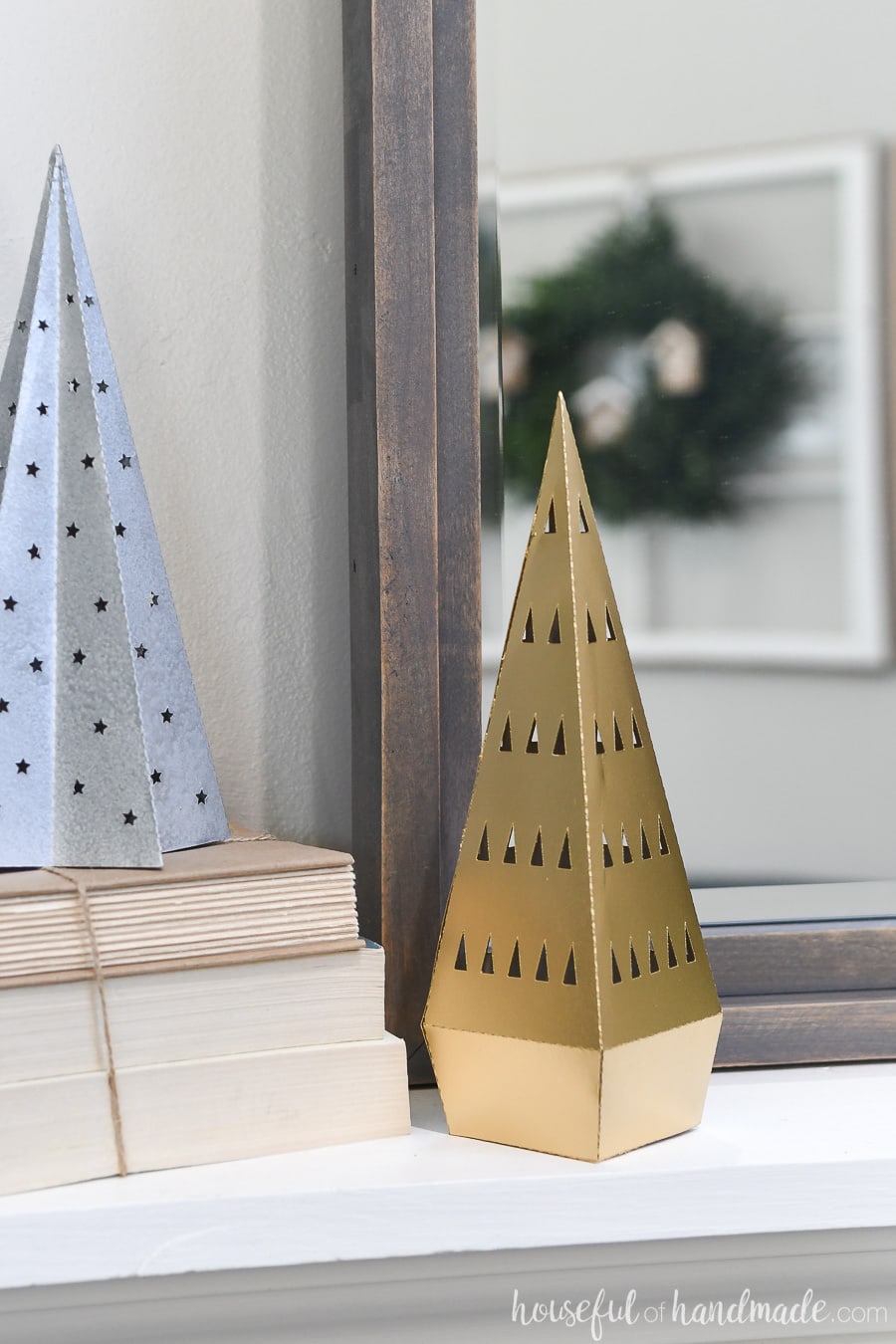 Gold modern Christmas tree made out of paper on a mantel.