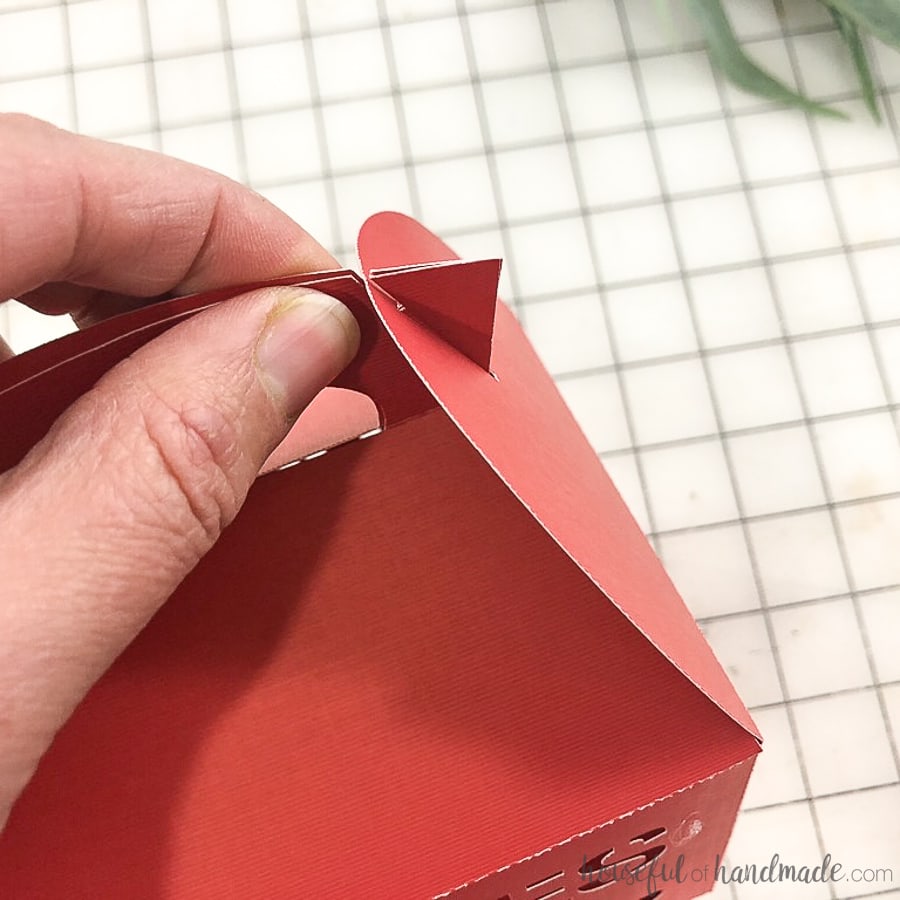 Inserting the side flaps into the handle notches of the gift boxes for cookies.