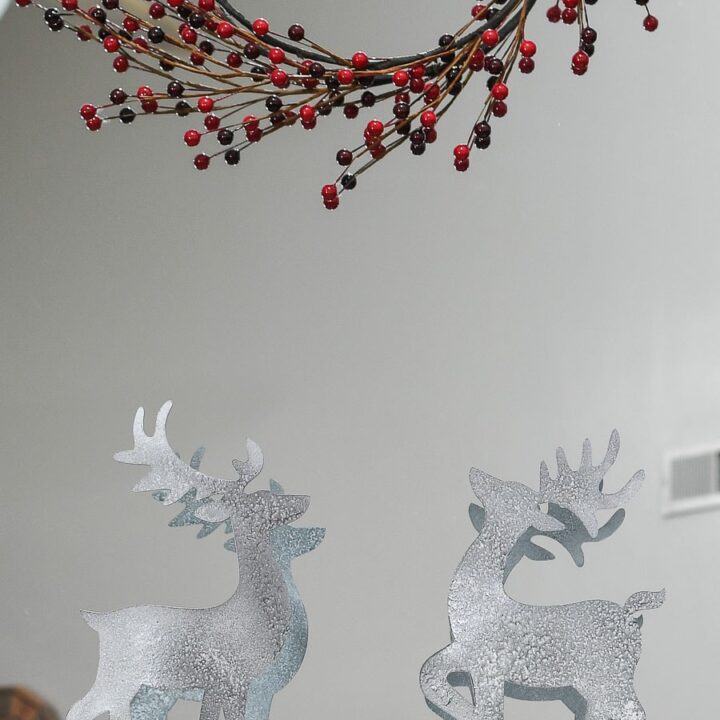 Christmas reindeer figurines made from paper and painted to look like metal on a Christmas mantel.