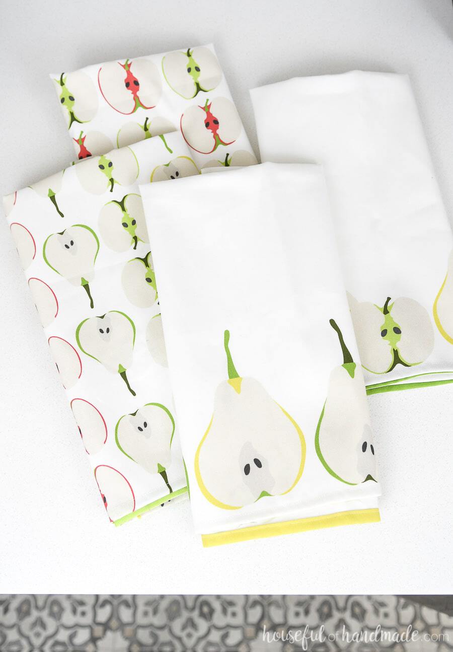 Four DIY tea towels made from apple and pear custom printed fabric.