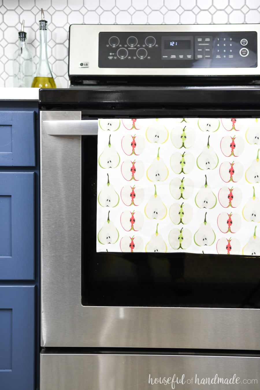 Sliced fruit design on a tea towel hanging on the handle of a stove. 