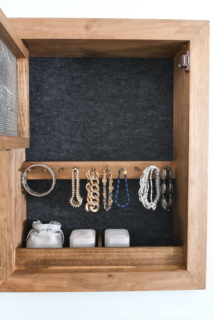 DIY jewelry cabinet opened up to see the felt back and bracelet rack.