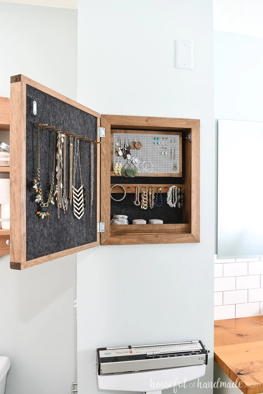 Wall jewelry organizer in the bathroom with storage for necklaces, earrings, bracelets and more.