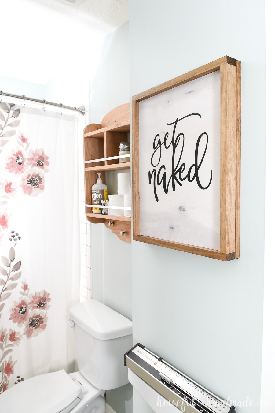 Wood sign in the bathroom hiding the wall jewelry cabinet. 