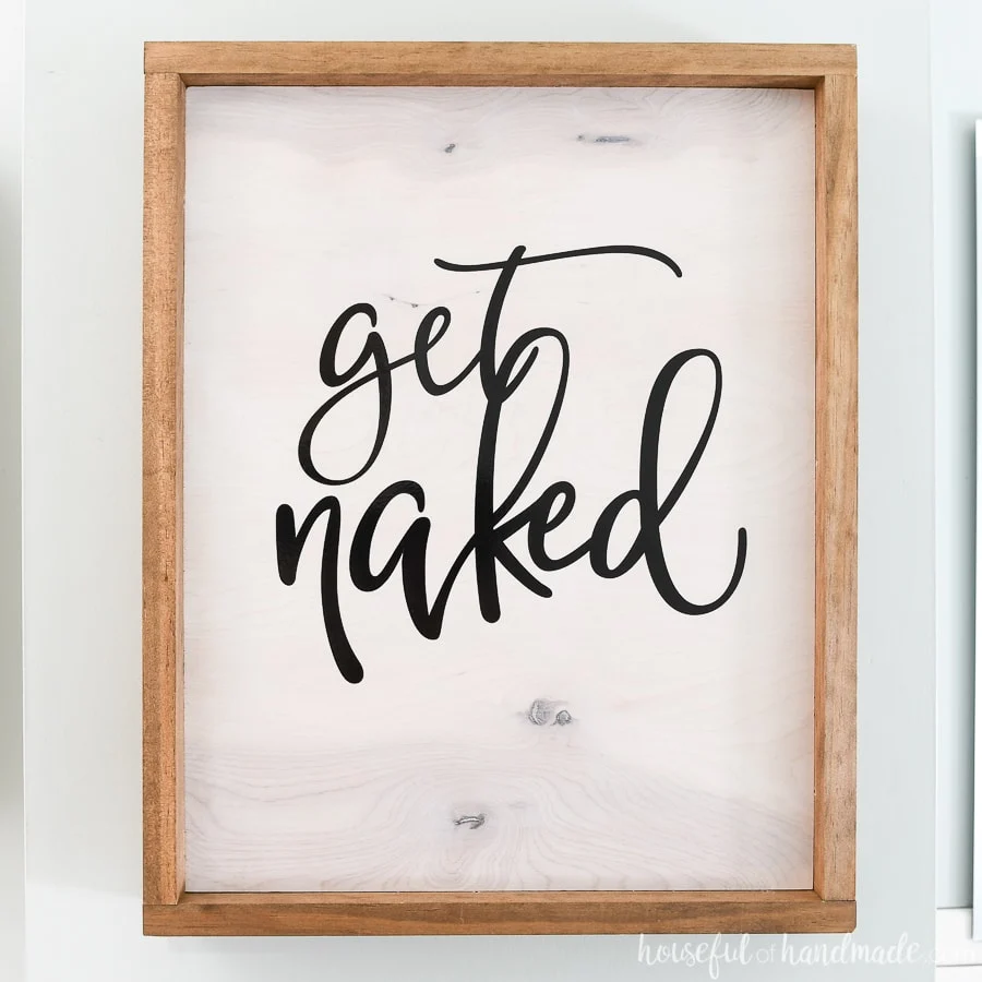 Get Naked wood sign is the front of the hidden DIY wall jewelry organizer.
