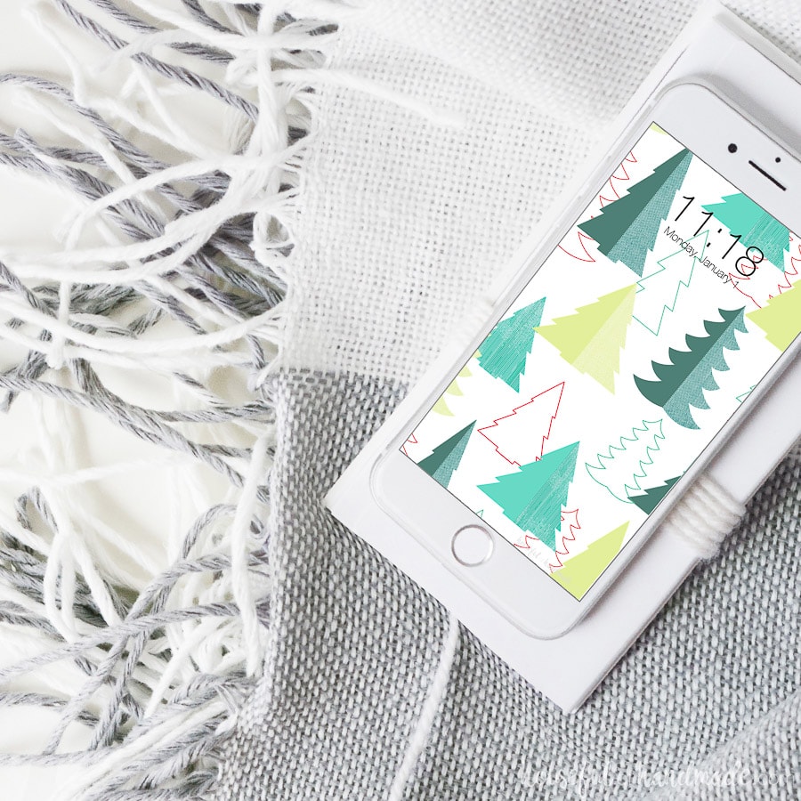 White iPhone with Christmas tree pattern on the back for the free digital wallpaper.