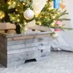 Square photo of the reclaimed wood Christmas tree stand cover with the tree inside.