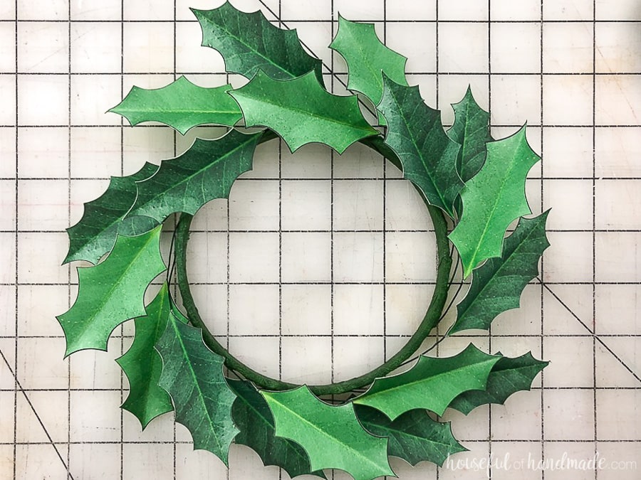 Fold the leaves of the paper holly wreath down around the embroidery hoop to create a wreath shape.