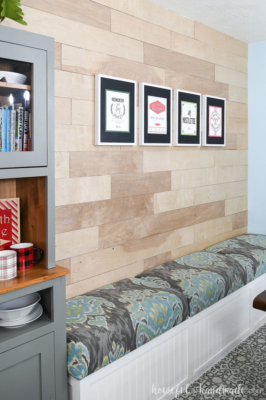 Dining room with a wood feature wall and DIY hutch with printable Christmas signs to look like North Pole shops. 