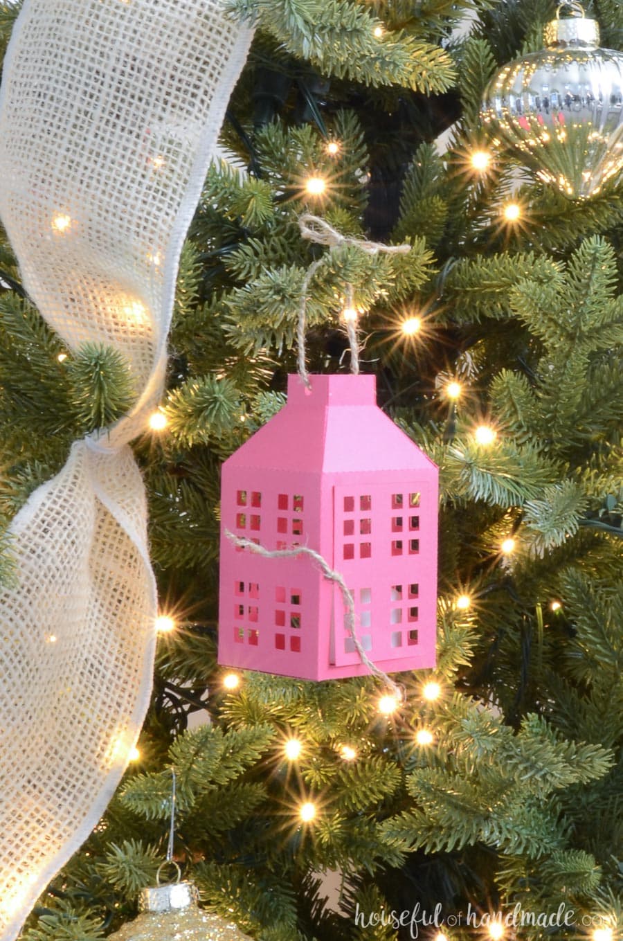 Rustic pink paper lantern Christmas ornament hanging on the Christmas tree. 