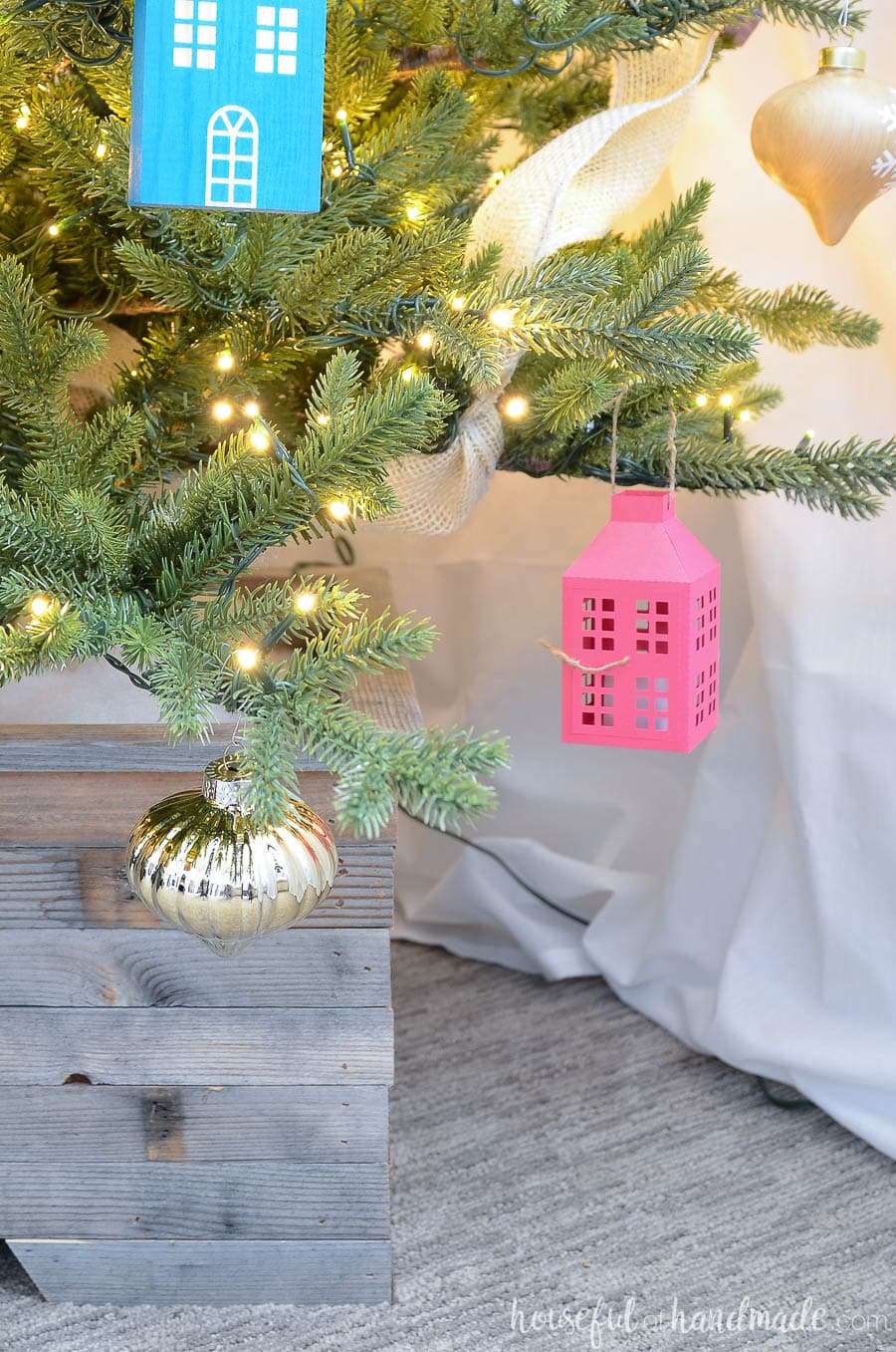 Christmas tree decorated with paper lantern Christmas ornament and wood house.