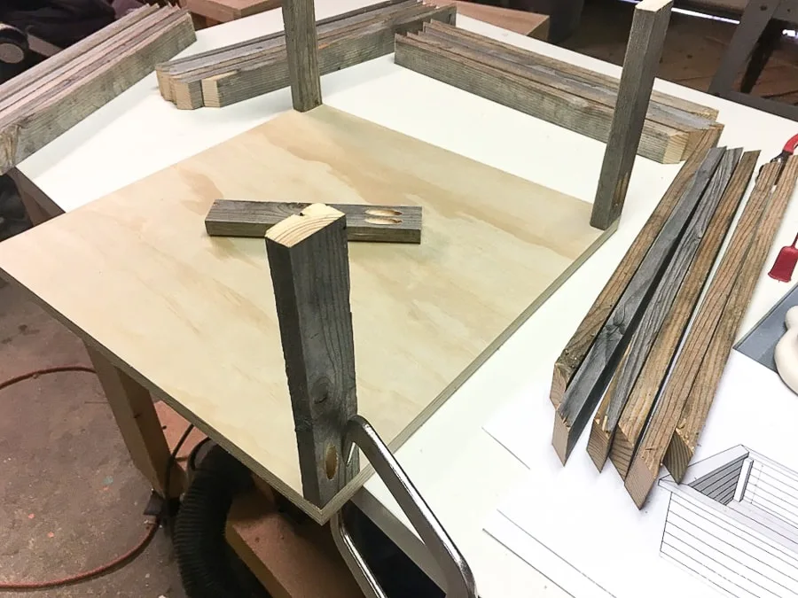 Attaching 1x2 support pieces of the wood Christmas tree stand to the plywood base.