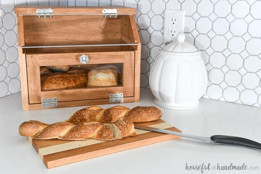 DIY bread box with pull out cutting board shelf with baguette on it.