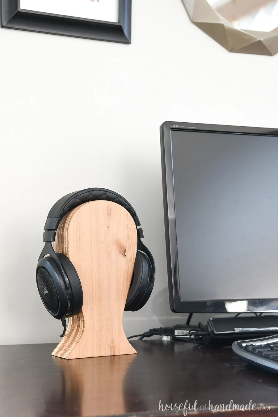 DIY wood headphone stand made from plywood scraps on a desk.