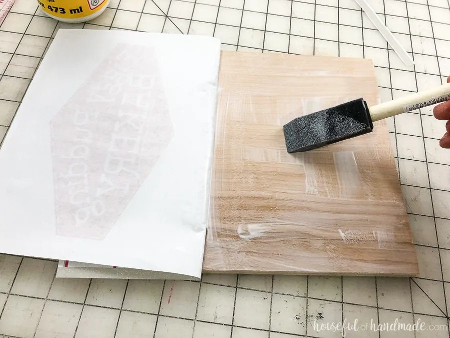 Attaching the printed art to the plywood DIY wood signs. 