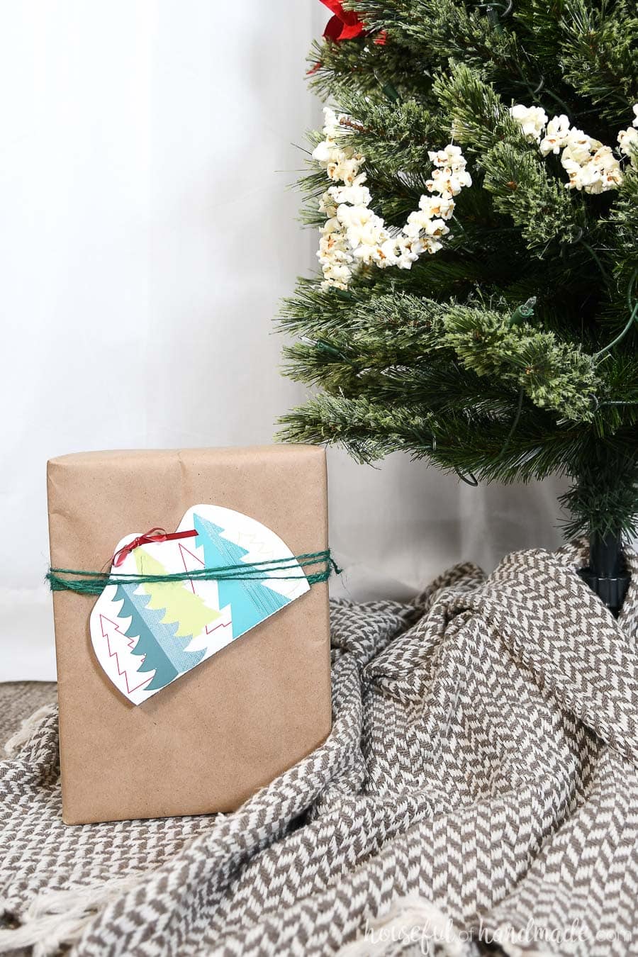 Christmas present wrapped under the tree with a gift card attached in a printable gift card holder. 