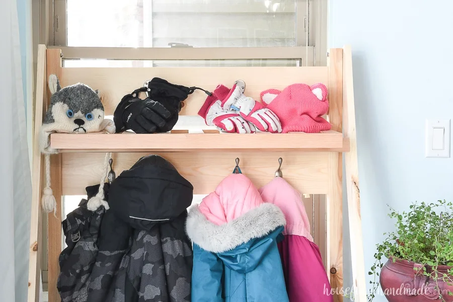 The top shelf of the collapsible storage rack with hats and gloves on it. 