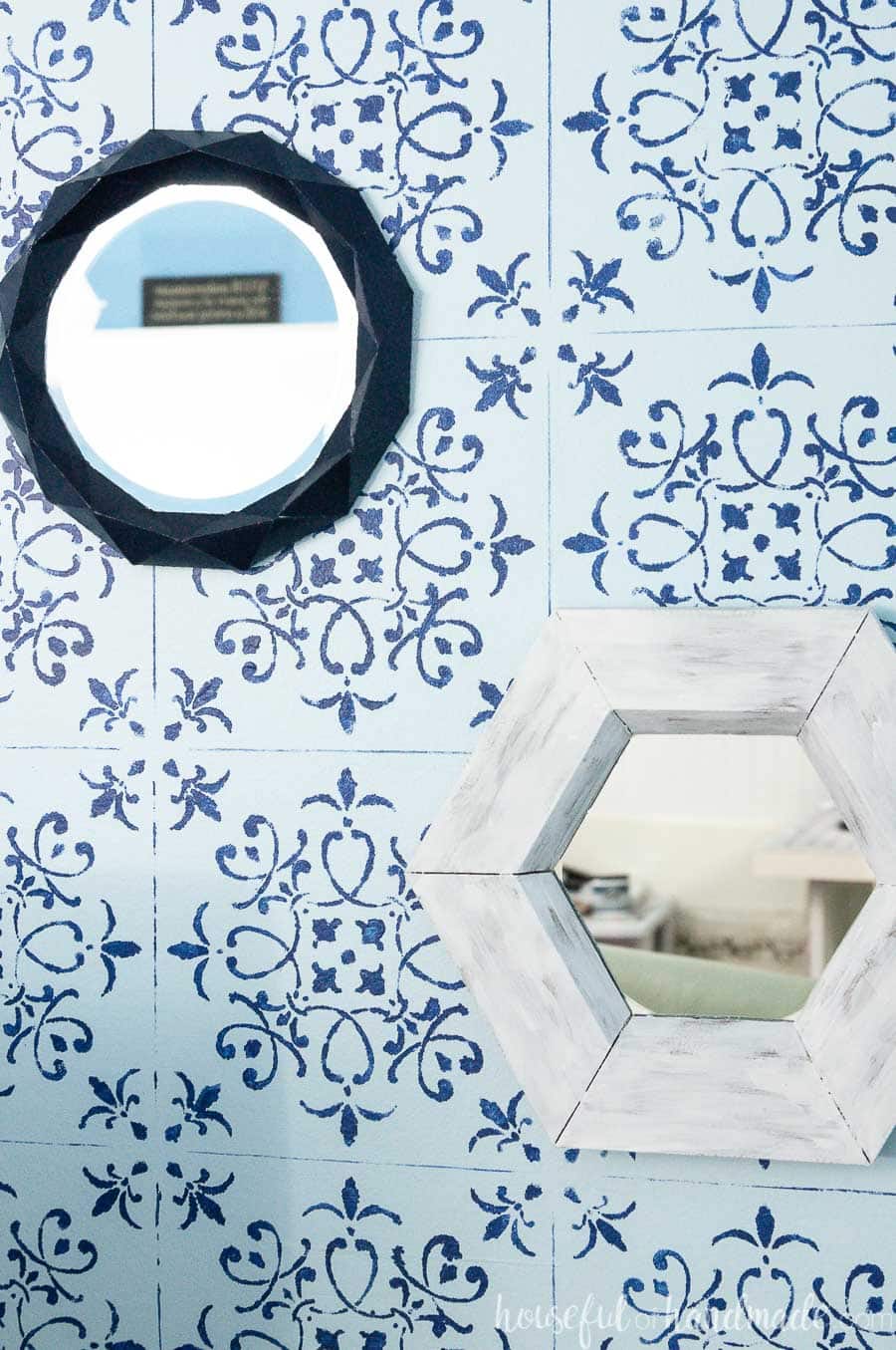 Close up of the small decorative mirrors on a blue and navy stenciled wall. 