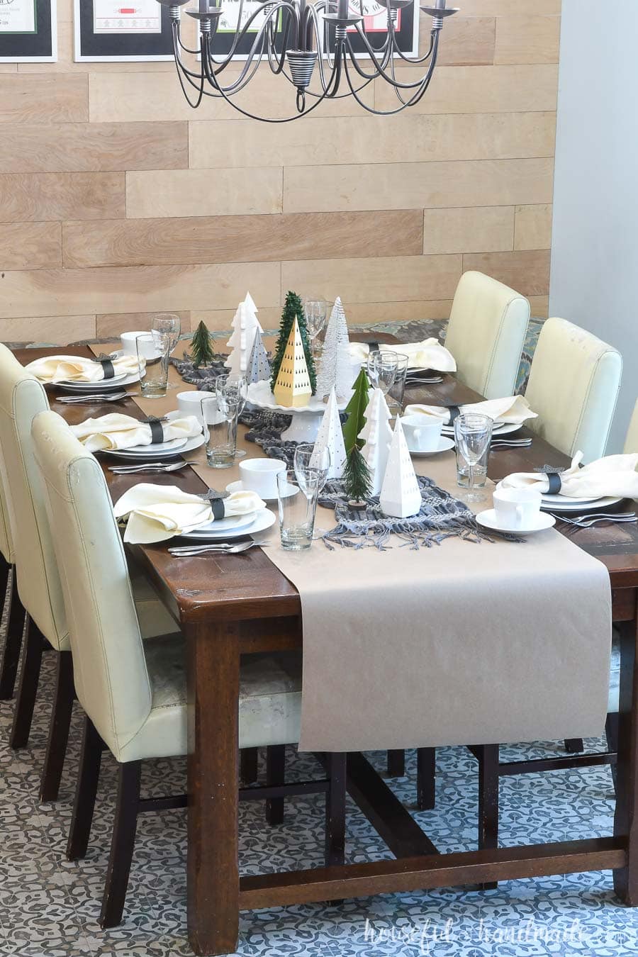 Dining room table decorated for winter with paper Christmas trees and paper napkin rings.