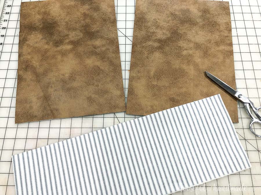 Piece of fabric and leather cut out for the DIY leather throw pillows.