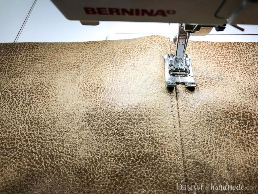 Top-stitching on either side of the leather seam holds it flat.