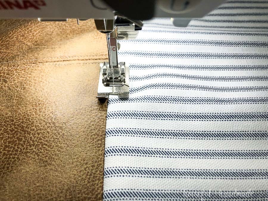 Sewing a top-stitch on the fabric side after adding it to the leather decorative pillow covers.