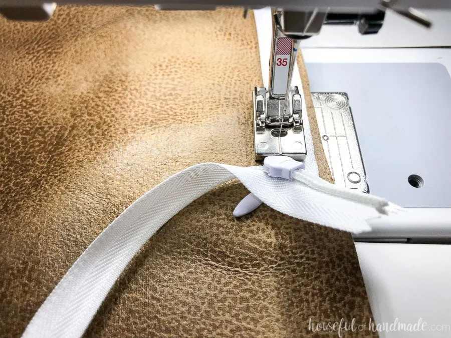 Close-up of sewing to the edge of the invisible zipper on the DIY pillow covers.