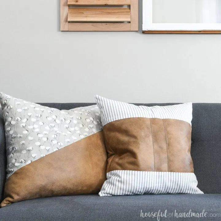 Two decorative leather pillow covers on a sofa.