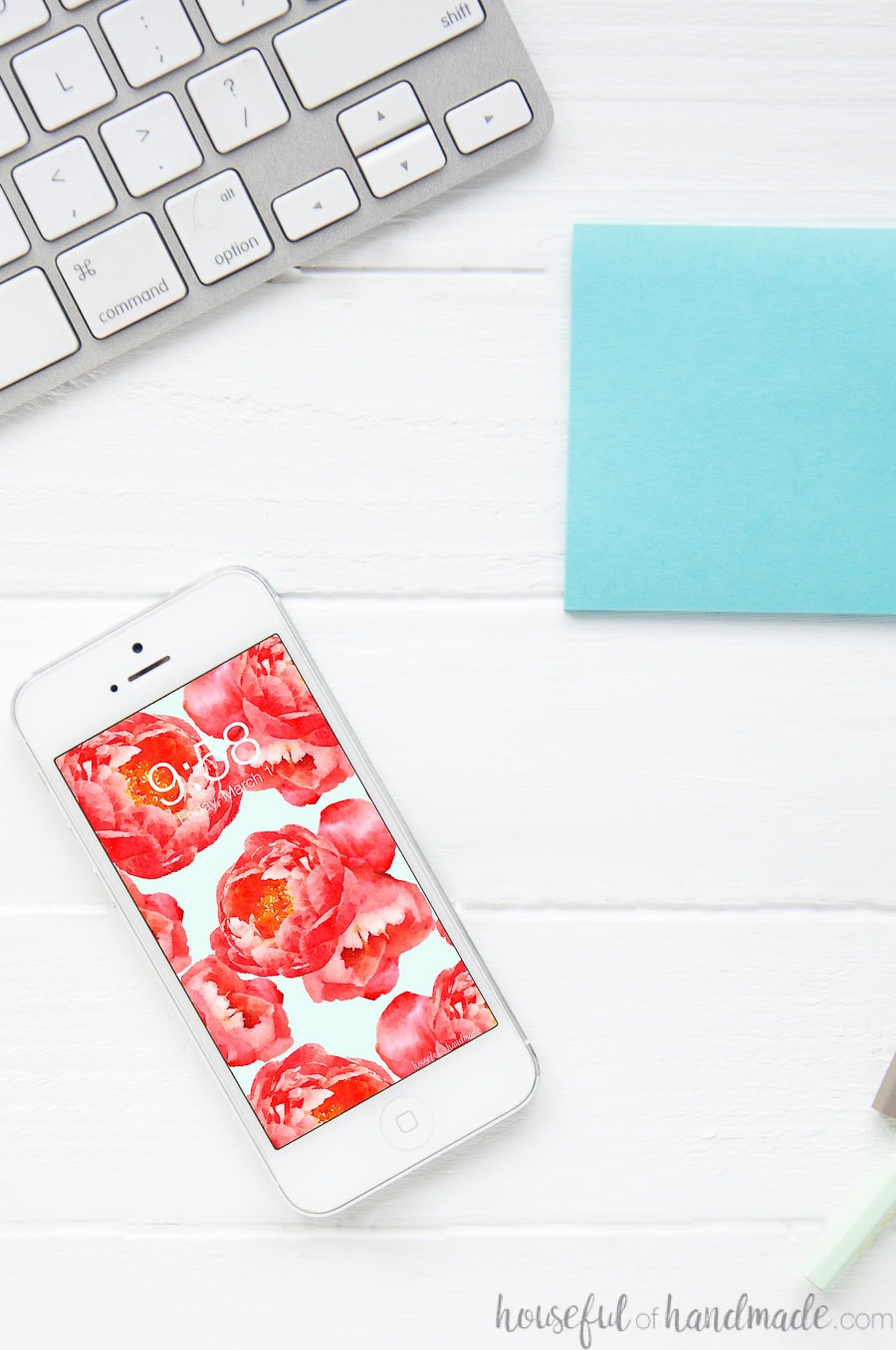 Floral phone wallpaper on a smartphone on a desk.