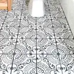 Square photo of black and white tile layout in bathroom.