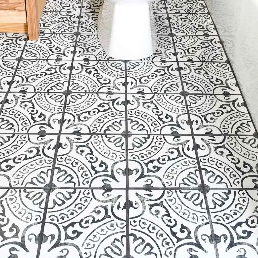 Square photo of black and white tile layout in bathroom.