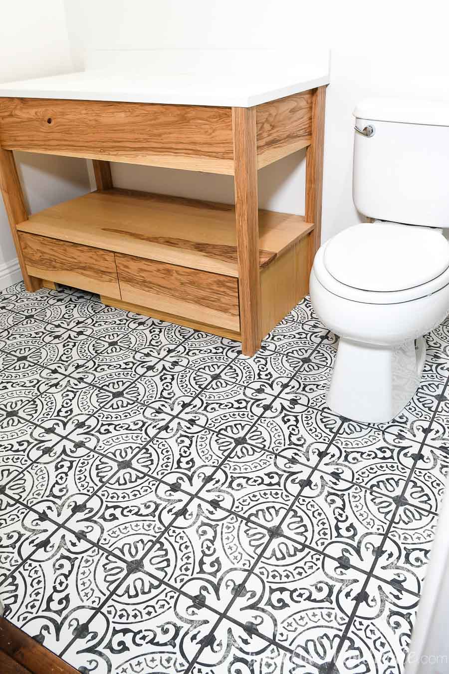 Bathroom with ash wood vanity and black and white porcelain floor tiles.