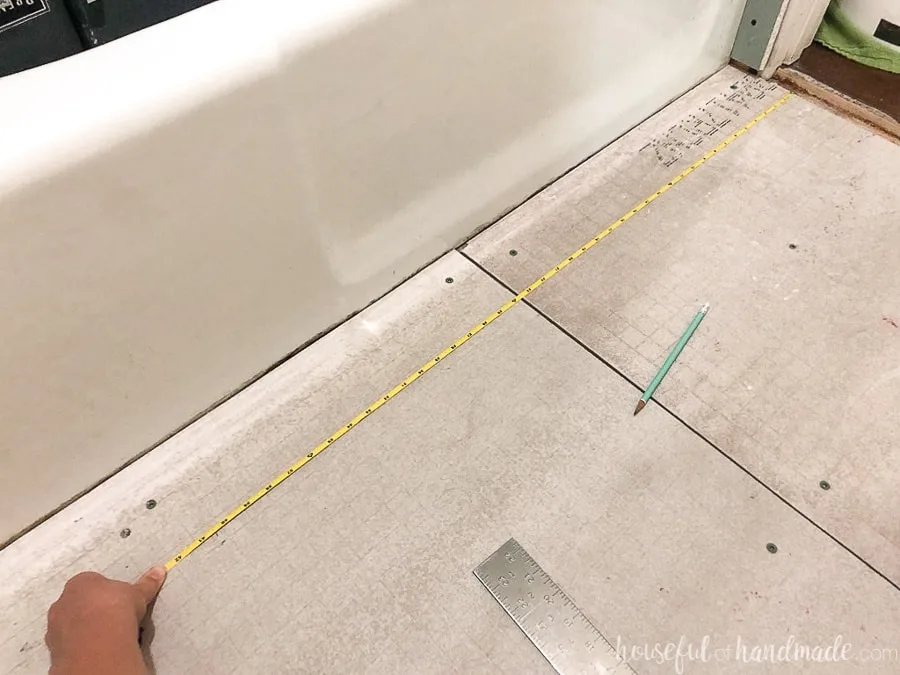 Measuring tape pulled to transfer tile layout measurement to the bathroom floor. 