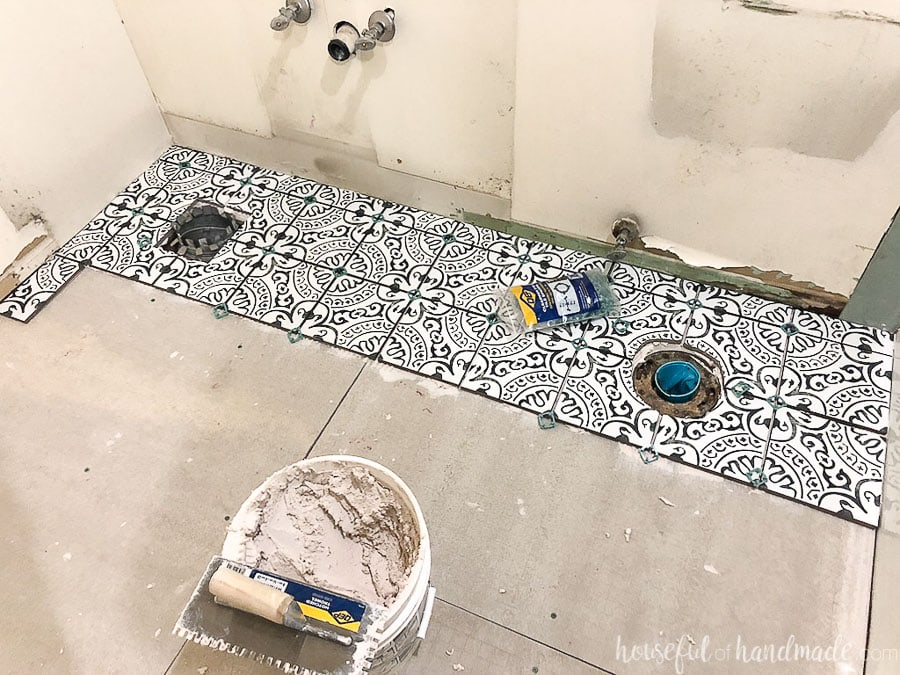 Black and white porcelain tiles installed along the back wall of the bathroom. 